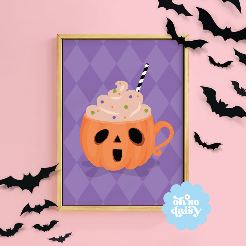 Halloween-themed pumpkin mug with whipped cream on a purple background, surrounded by black bats on a pink background.