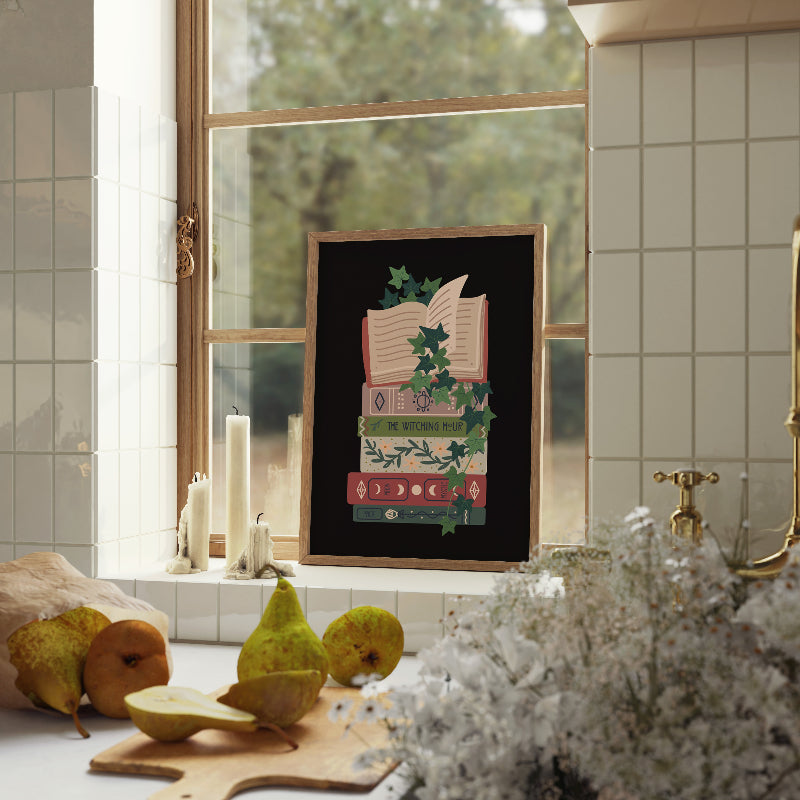 Framed artwork on a kitchen counter with pears and a window in the background