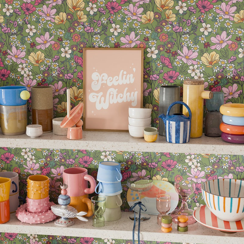 Shelf with colorful ceramic items against a floral wallpaper background