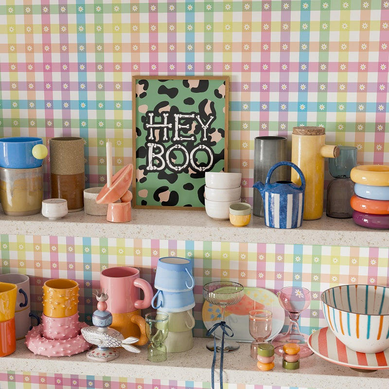 Colorful kitchenware on a shelf against a pastel checkered wall