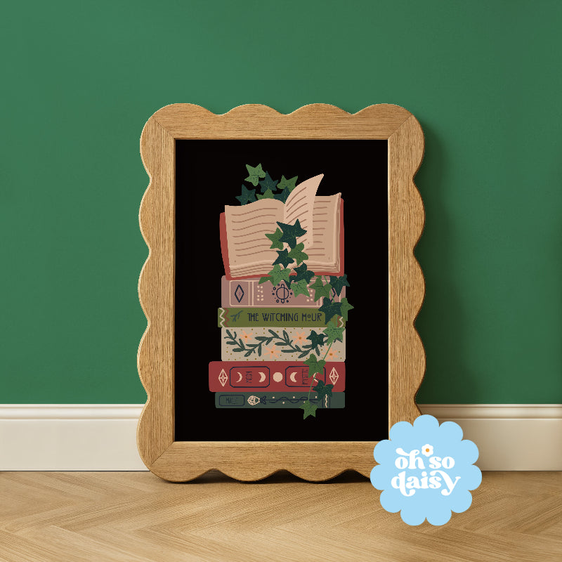 Decorative framed artwork with books and greenery on a black background, against a green wall.