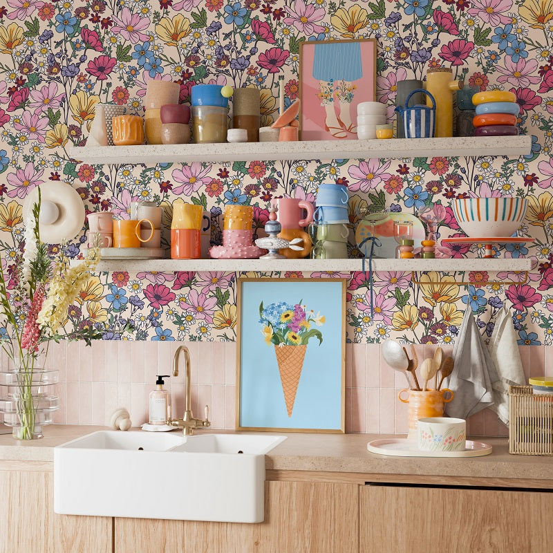 The image showcases a vibrant and eclectic kitchen scene, featuring a variety of colorful dishes, cups, and utensils arranged on shelves and countertops. The kitchen is adorned with a floral wallpaper, adding a touch of nature and warmth to the space. The overall design and arrangement of the items create a lively and visually appealing atmosphere.