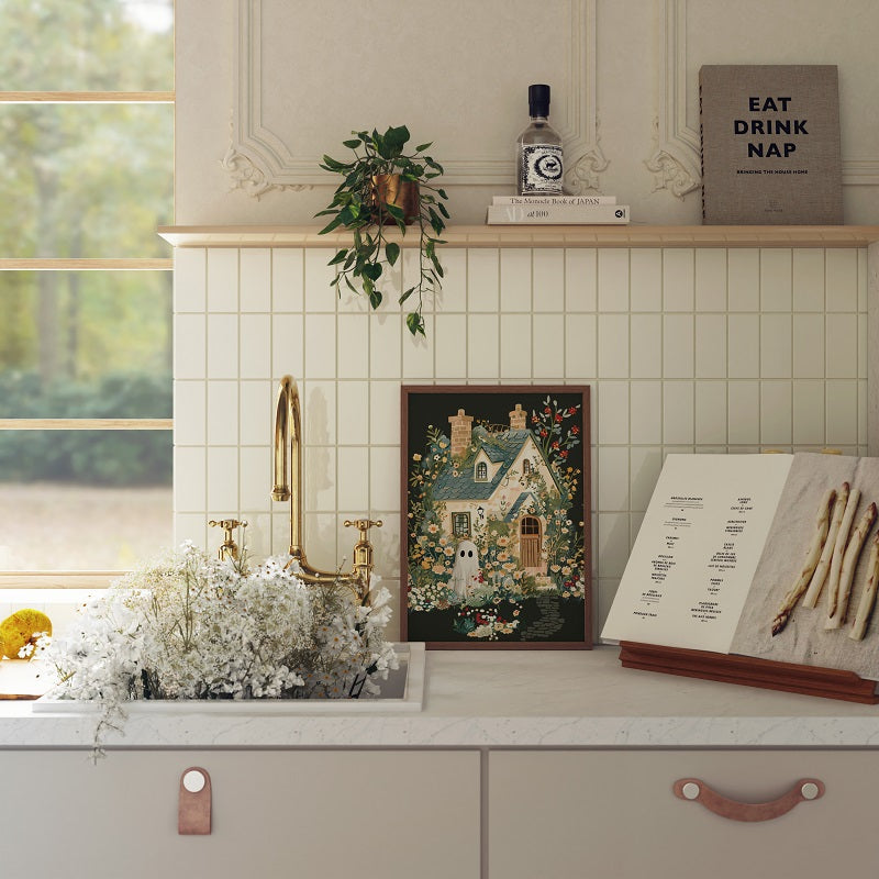 Kitchen counter with decorative items including a painting, plant, and books.