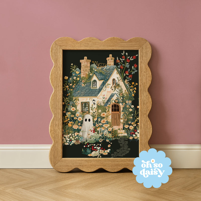 Decorative framed artwork with a house and ghost design on a pink wall, featuring 'oh so daisy' brand.