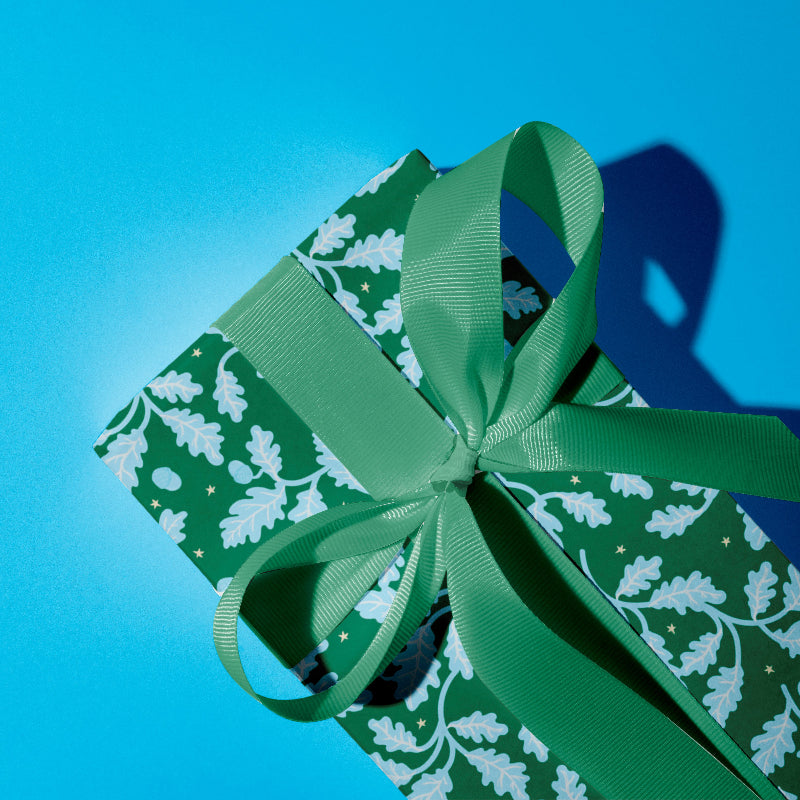 Say hello to Acorn Oak gift wrap. Featuring bright blue oak leaves and acorns scattered across a cheerful green background, sprinkled with twinkling hand-drawn stars, this gift wrap is full of festive charm and whimsy. Perfect for mixing and matching with our floral Hollyhock prints or wavy candy cane stripes, it’s a joyful way to make your gifts feel extra special this Christmas.