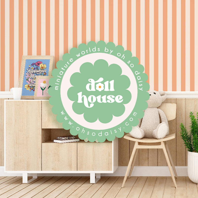 Dollhouse with a 'doll house' sign and a teddy bear on a chair against a striped wall.