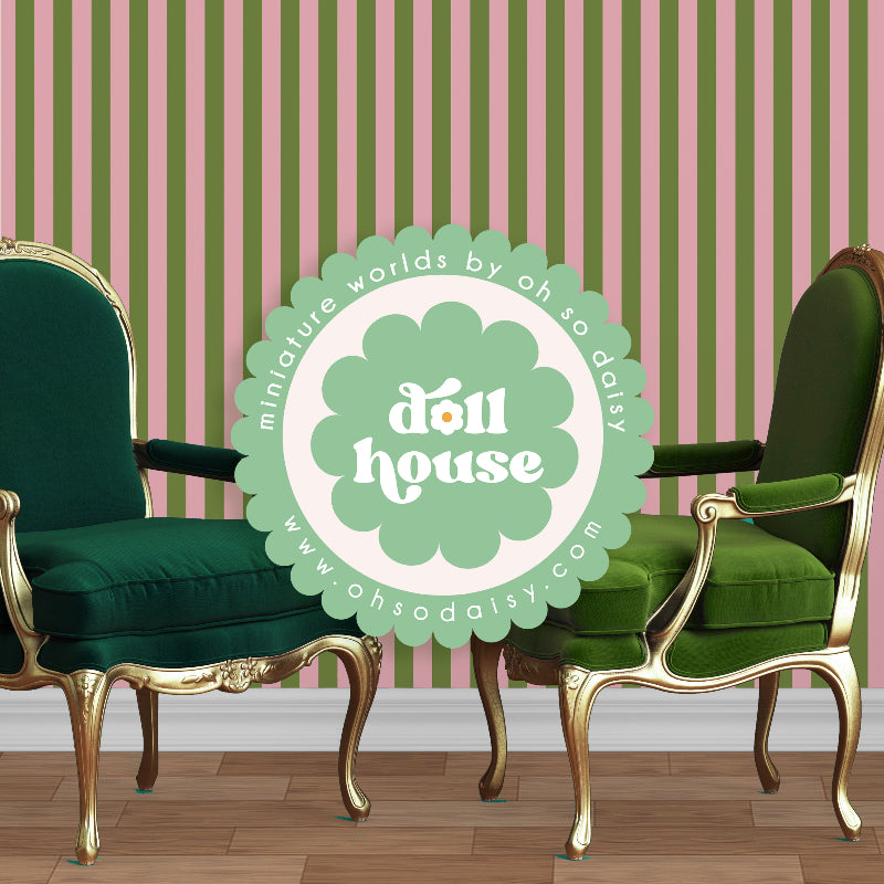 Two green chairs with gold legs in front of a striped wall with 'doll house' logo.