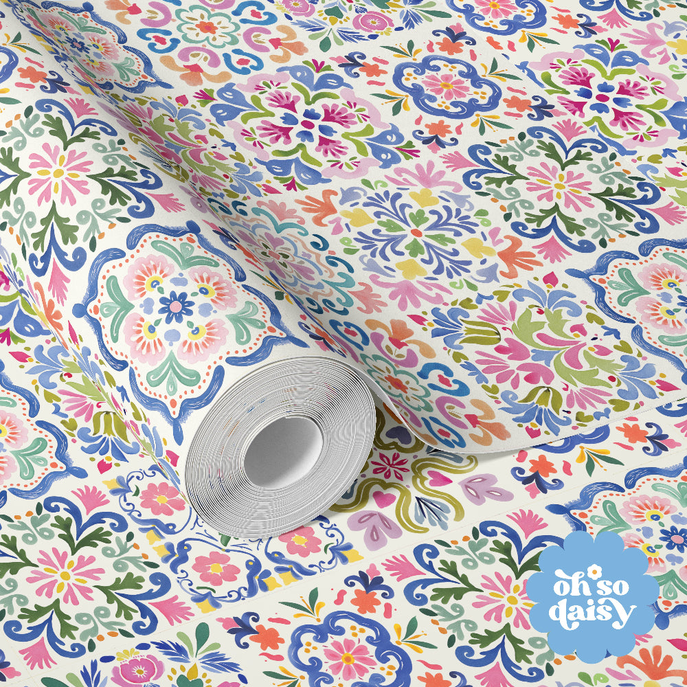 Caletta Mosaic wallpaper featuring a colourful Mediterranean tile-inspired pattern with intricate floral motifs, styled in a light bedroom setting