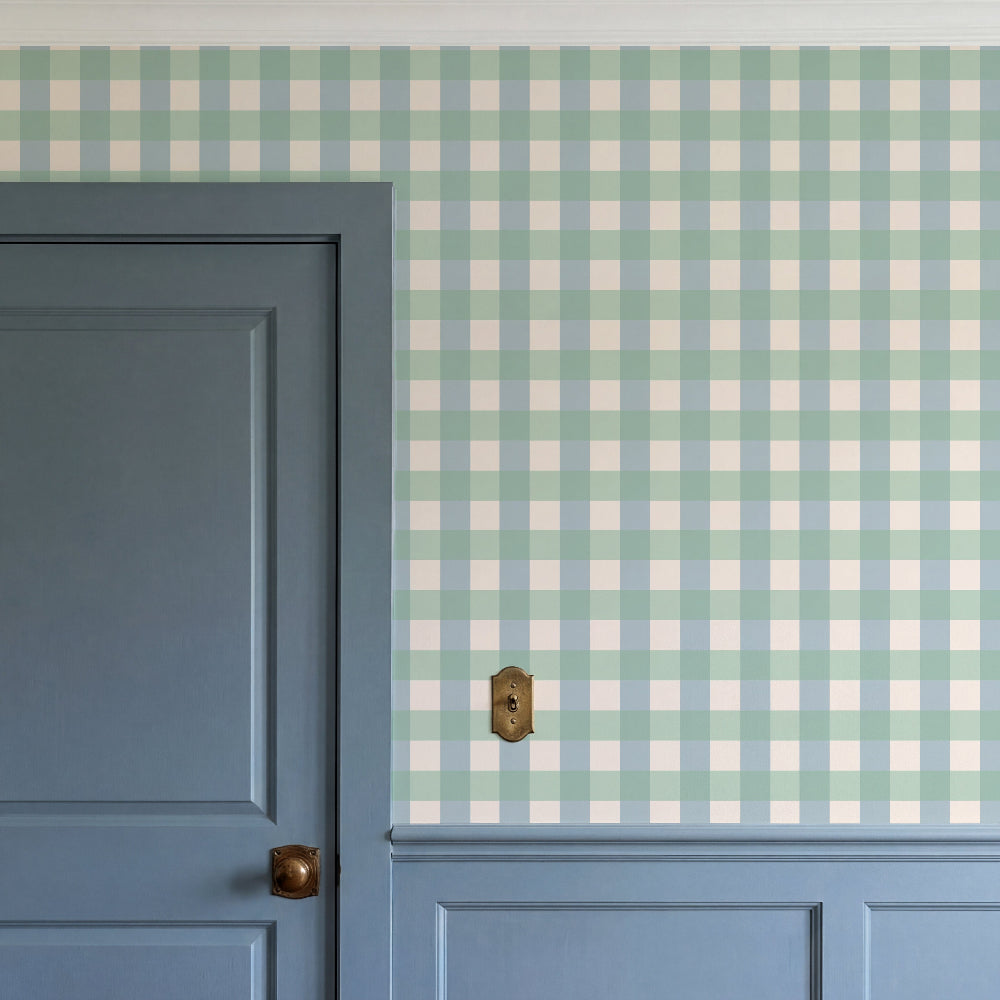 A close-up of a wall with a light blue and white gingham check pattern above a blue paneled door and matching wainscoting.