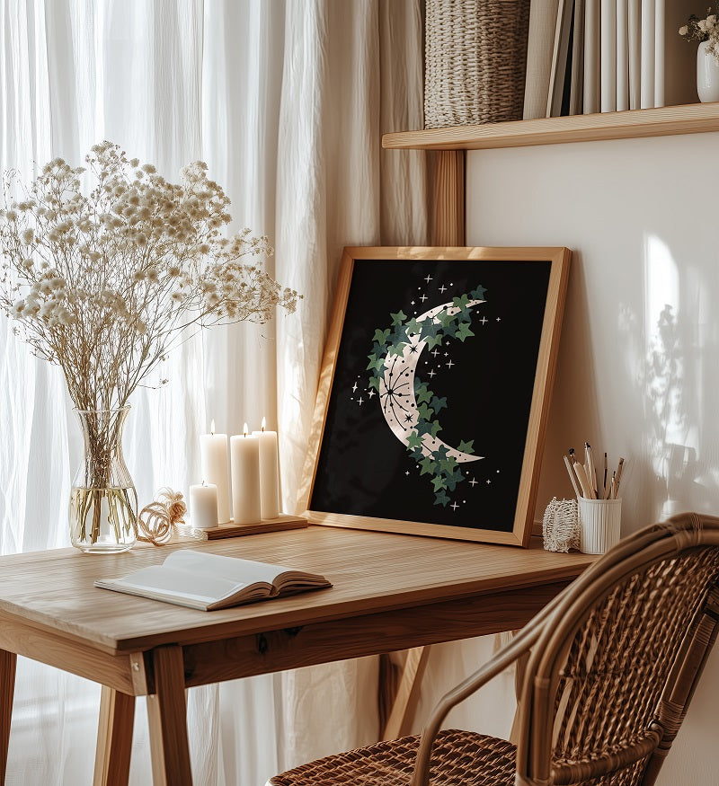 Wooden desk with framed artwork, candles, and books in a cozy room.