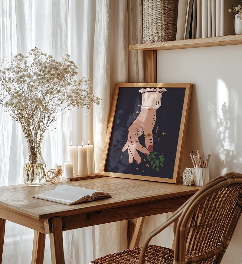 Wooden desk with framed artwork, candles, and books in a cozy room.