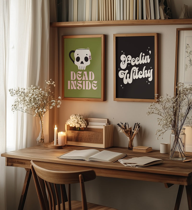 Wooden desk with books, a candle, and framed pictures in a cozy room.